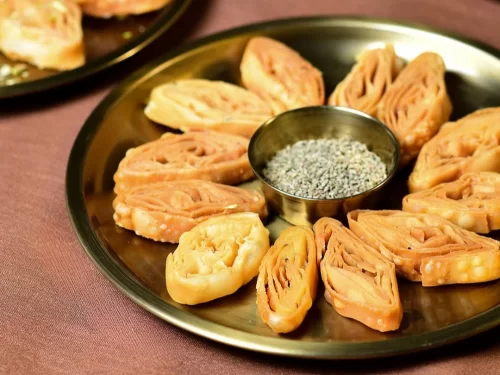 Khaja in crisp layered fried pastry with sugar syrup glaze, authentic Indian traditional sweet, crunchy Indian cuisine delight.