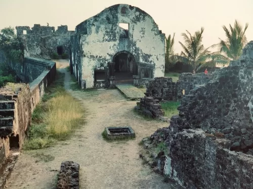 Historic ruins of Korlai Fort in Maharashtra, featuring old stone walls and a chapel structure overlooking the Arabian Sea, a heritage site included in Maharashtra tour packages.