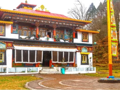 Lachung Monastery Sikkim colorful facade with prayer flags amid misty pine hills, perfect cultural North Sikkim tour package.