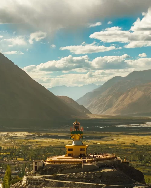 Diskit Monastery in Nubra Valley Ladakh with giant Maitreya Buddha statue overlooking Himalayan landscape, a spiritual highlight of Ladakh tour packages