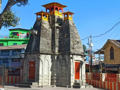 Maa Nanda Devi Temple in Almora, Uttarakhand featuring its tall stone structure and vibrant red doors, a revered cultural landmark included in Uttarakhand tour packages