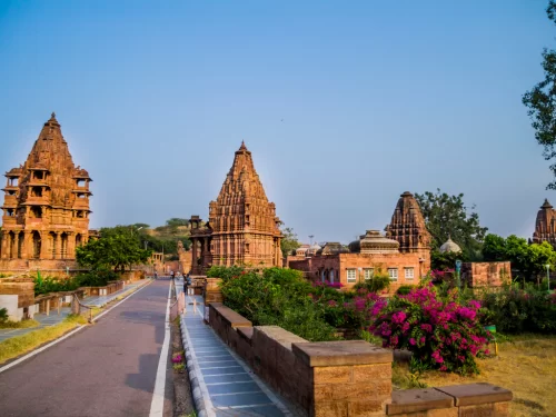 Mandore Garden at Jodhpur during golden hour, featuring red sandstone shikharas, cenotaphs, pathways, bougainvillea, perfect heritage experience Rajasthan tour packages.