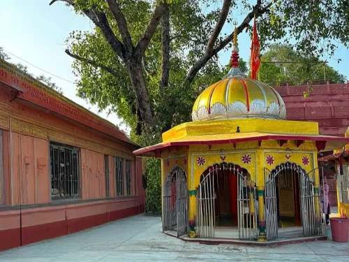 Mankameshwar Temple in Ranikhet, Uttarakhand with its vibrant yellow shrine and peaceful courtyard, a revered spiritual site included in Uttarakhand tour packages 