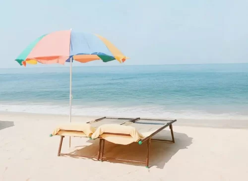 Marari Beach in Kerala, tranquil Arabian Sea shoreline with golden sands and relaxing beach loungers.