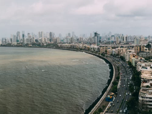 Marine Drive Mumbai aerial view skyscrapers Arabian Sea cloudy sky curving promenade busy traffic urban skyline, perfect South Mumbai walking tour sunset photography package.