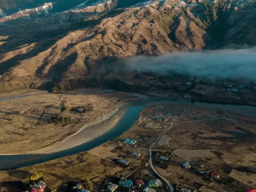 Mechuka View Point breathtaking aerial landscape of winding river and rugged mountains under misty skies in Arunachal Pradesh Package.