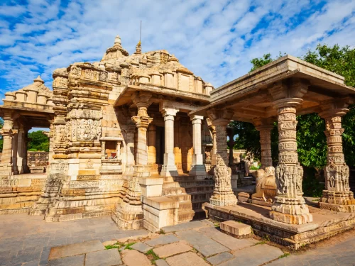 Meera Temple at Chittorgarh Fort in Rajasthan showcasing intricate Indo-Aryan carvings, pillars, and torana with trees, perfect Rajasthan tour package