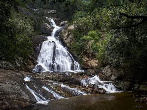 Monkey Falls, scenic waterfall near Pollachi in Anamalai Hills surrounded by dense forest and rocky terrain