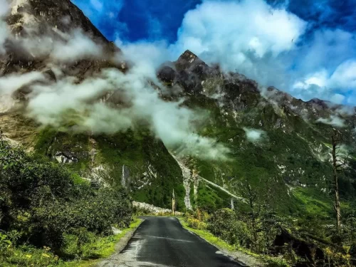 Misty mountain road to Katao Lachung Sikkim amid green valleys and clouds, perfect adventure North Sikkim tour package.