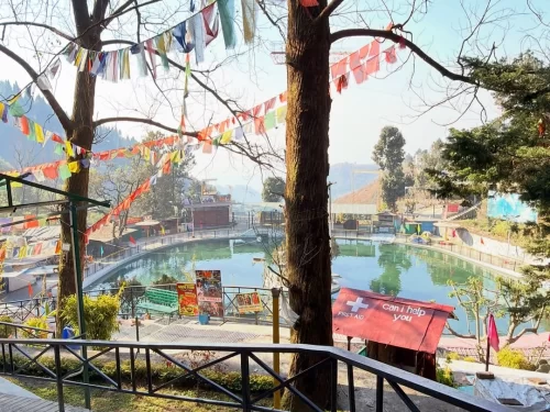 Mussoorie Lake scenic boating spot with calm waters, hillside views and colorful flags in Uttarakhand