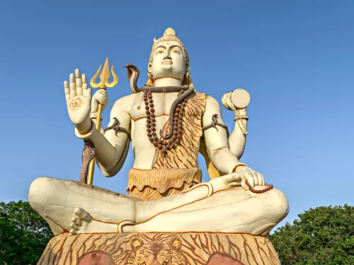 Nageshwar Jyotirlinga Temple in Dwarka during clear day, featuring giant seated Shiva statue with trishul, damaru, snake, perfect pilgrimage experience with Gujarat tour packages.