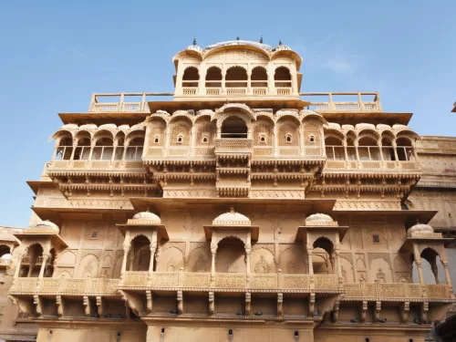 Nathmal Ki Haveli Jaisalmer ornate sandstone facade multi-tier balconies domes jharokhas blue sky featured in Rajasthan tour packages