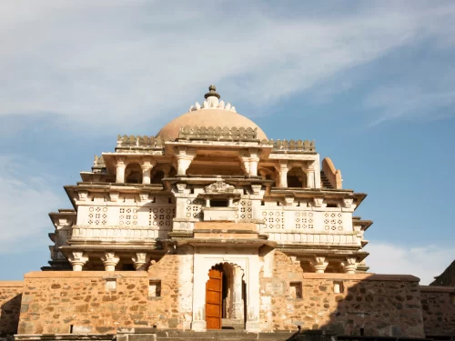 Neelkanth Mahadev Temple at Kumbhalgarh during clear day, featuring ornate domes, jharokhas, stone arches, perfect spiritual experience Rajasthan tour packages. 
