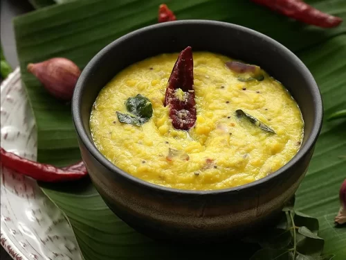 Parippu Curry, a traditional Kerala dish made with creamy cooked lentils, coconut, curry leaves, and tempered spices, served in a rustic bowl.