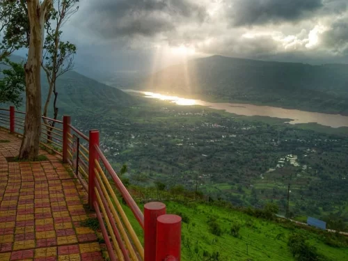 View from Parsi Point in Panchgani, Maharashtra, overlooking the Krishna Valley and Dhom Dam backwaters under dramatic sunlight, a scenic highlight featured in Maharashtra tour packages.