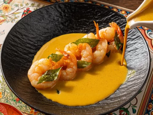 Houseboat at Alleppey backwaters during sunset, featuring palm trees and calm lagoons, romantic Kerala tour package.