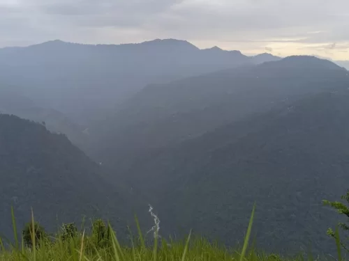 Pujay Dara View Point in Kalimpong, West Bengal, offering panoramic views of mist-covered hills and a winding river valley, a scenic stop often included in West Bengal tour packages.