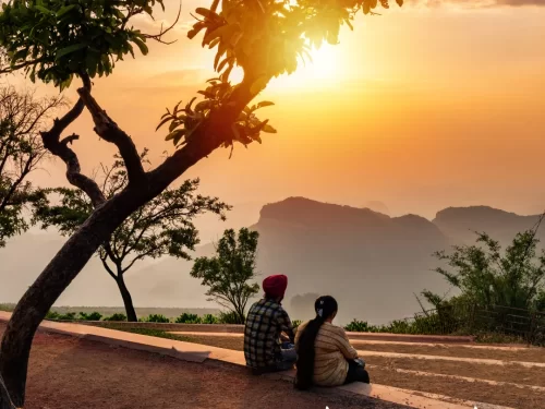 Sunset view from Rajendra Giri Sunset Point in Pachmarhi, Madhya Pradesh, with visitors overlooking layered hills and golden evening skies, a scenic highlight included in Madhya Pradesh tour packages