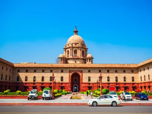 Rashtrapati Bhavan at New Delhi on sunny day, featuring sandstone dome and forecourt, perfect heritage Delhi tour package.