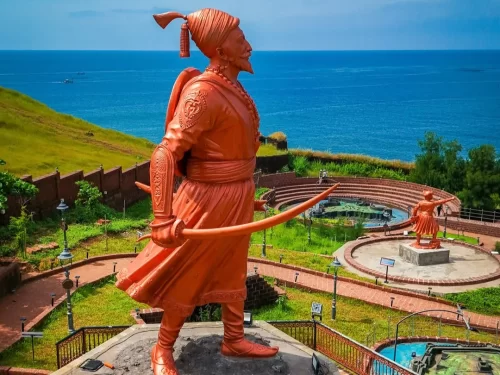 Statue overlooking the Arabian Sea at Ratna Durga Fort in Ratnagiri, Maharashtra, surrounded by coastal views and historic fort walls, a prominent attraction included in Maharashtra tour packages.