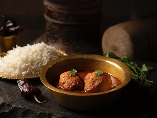 Shikara ride at Dal Lake Srinagar during sunset, featuring houseboats and mountains, romantic Srinagar tour package.