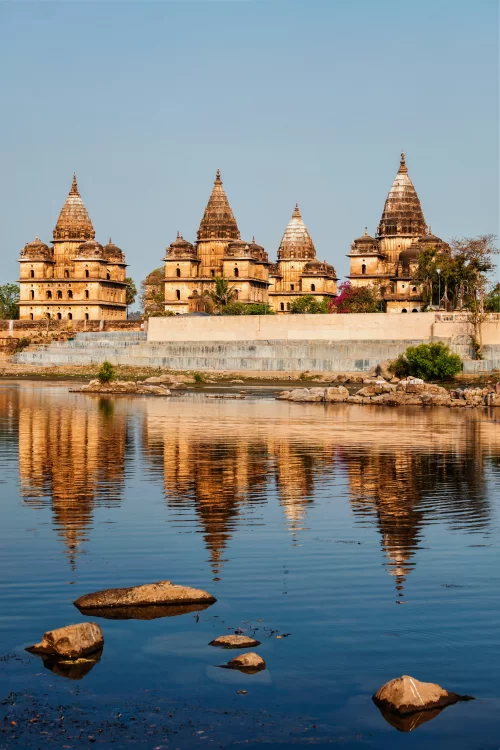 Royal cenotaphs of Orchha reflected in Betwa River showcasing grand Bundela architecture and serene heritage landscape ideal for Orchha sightseeing tours and Madhya Pradesh cultural travel packages India