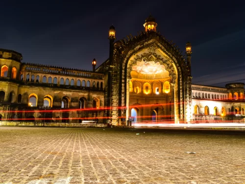Rumi Darwaza illuminated at night in Lucknow, featuring light trails arches towers buildings, perfect romantic Uttar Pradesh tour package.