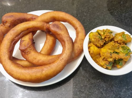 Sael Roti is a traditional Nepali ring-shaped rice bread, deep-fried to golden perfection and served crisp outside with a soft, fluffy center.