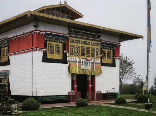 Sanga Choeling Monastery during misty weather, featuring traditional Tibetan architecture and prayer flags, perfect spiritual Sikkim tour package.