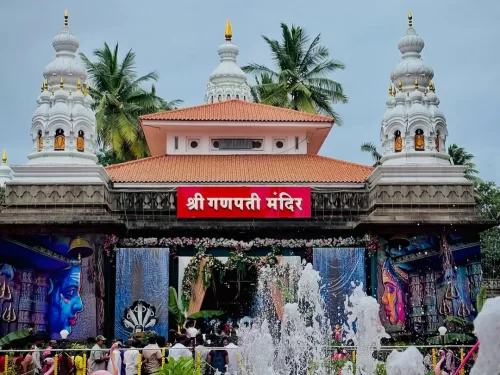 Sangli Shri Ganpati Temple in Maharashtra featuring the grand temple entrance with white domes, vibrant murals and devotees gathered for darshan, a prominent spiritual landmark included in Maharashtra tour packages 