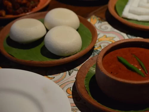 Sunset at Goa beach during evening, featuring palm trees and boats, perfect romantic experience Goa tour package.