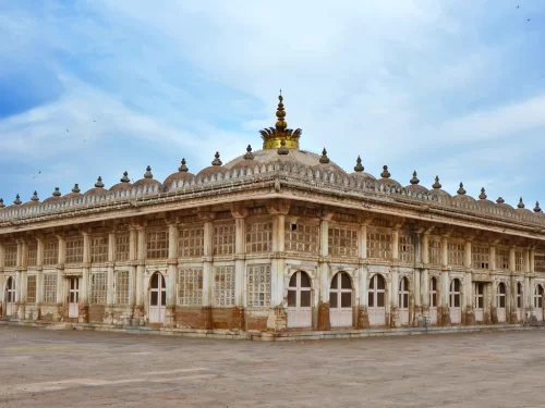 Majestic mausoleum at Sarkhej Roza Ahmedabad during daylight, featuring golden dome and intricate jali screens, perfect cultural Gujarat tour package.