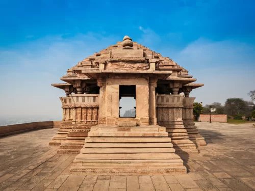 Sasbahu Bahu Temple at Gwalior Fort under clear skies, featuring carved dome and elevated platform, perfect heritage experience with Madhya Pradesh tour packages.