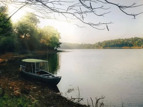 Sasthamcotta Lake, Kerala largest freshwater lake with tranquil waters, forested banks and country boat at sunrise