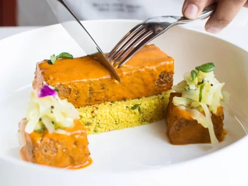 Sepu Vadi, traditional Himachali lentil dumplings simmered in rich spinach gravy, served with grains and fresh garnish, classic festive mountain delicacy.