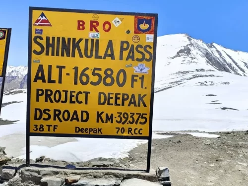 BRO Shinkula Pass sign Alt 16580 ft Lahaul Spiti Himachal Pradesh sunny day, snow peaks Zanskar ranges; perfect Ladakh Manali tour package
