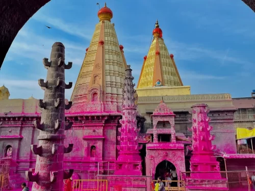 Shree Jyotiba Devsthan temple in Wadi Ratnagiri near Kolhapur, Maharashtra, with tall spires and pink-colored festival decorations, a popular pilgrimage site featured in Maharashtra tour packages.