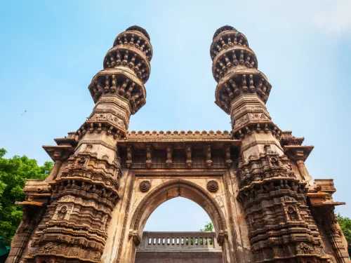 Shaking minarets at Sidi Bashir Mosque Ahmedabad during daylight, featuring carved towers and arched gateway, perfect cultural Gujarat tour package.