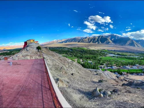 Spituk Gompa Leh panoramic terrace view yellow red monastery snowy Zanskar mountains green valley blue skies, perfect Ladakh spiritual monastery tour package.