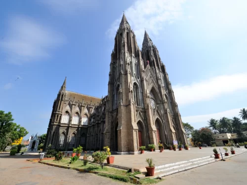 St. Philomena's Cathedral in Mysore during clear morning, featuring grand neo-gothic facade and spacious courtyard, perfect heritage Karnataka tour package