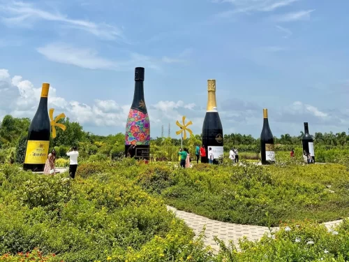 Sula Vineyards in Maharashtra featuring giant wine bottle installations set amid lush vineyards and landscaped gardens, a popular wine tourism destination included in Maharashtra tour packages