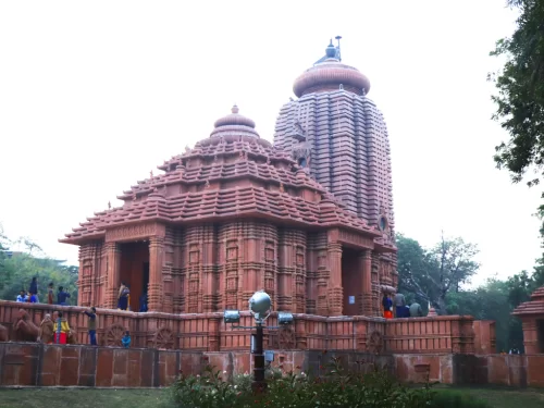 Sun Temple Gwalior temple complex during clear afternoon, featuring visitors at stepped jagamohana entrance beside towering rekha deul vimana amid lush gardens, perfect heritage experience in Madhya Pradesh tour package.