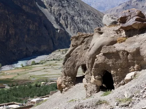 Tabo Caves natural arch at Tabo Spiti Valley during clear weather, featuring Spiti River green fields villages rugged mountains, perfect adventure experience Spiti Valley Himachal tour package.