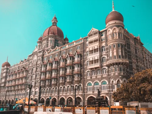 Taj Mahal Palace Mumbai iconic Indo-Saracenic heritage hotel red domes Arabian Sea Gateway of India blue sky, perfect luxury Colaba tour package. 