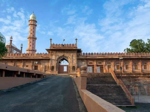 Taj-ul-Masajid entrance at Bhopal during clear daylight, featuring pink minaret grand sandstone gate stairs, perfect cultural Madhya Pradesh tour package.