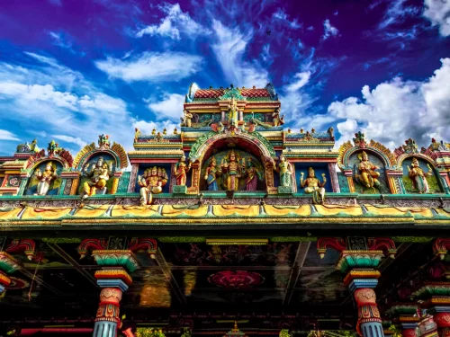 Tapovan Temple Vadodara showcases vibrant Dravidian-style gopuram with intricate deity carvings under dramatic skies, spiritual heritage perfect for Gujarat tour packages.