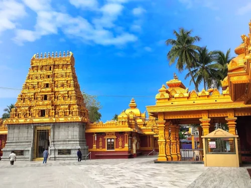 Kudroli Sri Gokarnanatha Kshetra in Mangaluru during daylight, featuring golden temple towers and palm trees, perfect spiritual experience, Karnataka tour packages.