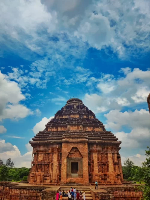 Magnificent Konark Sun Temple in Odisha under blue sky with detailed stone carvings attracting travelers through Odisha tour packages