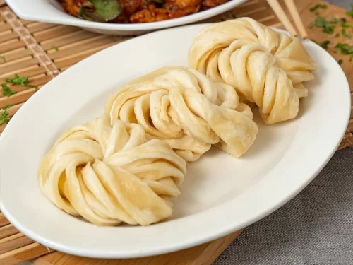 Tingmo is a soft, fluffy Tibetan steamed bread with delicate twisted layers, perfect for soaking up rich curries and gravies.