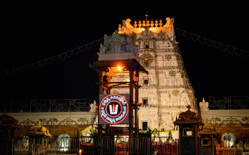 Gopuram at Tirumala Venkateswara Temple during night, featuring illuminated tower and TTD sign, perfect spiritual experience Tirupati tour package.